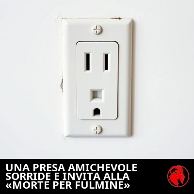 Una presa elettrica a muro statunitense a un solo punto, le cui fessure e il foro di terra somigliano a un volto sorridente e amichevole. Didascalia: la presa amichevole sorride e invita alla «Morte Fulminante».